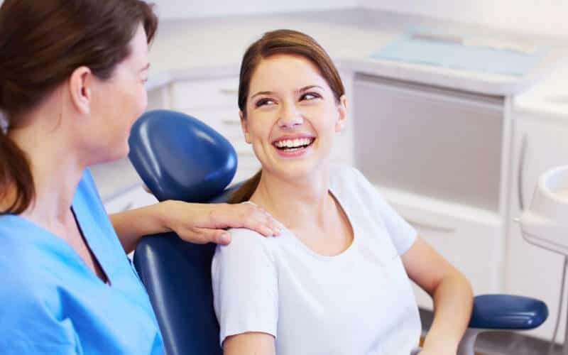 Smiling patient with dentist in Robstown dental office discussing Snap-On-Smile treatment.